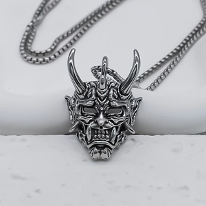Macro view of silver Hannya demon mask pendant with punk style and detailed engraving