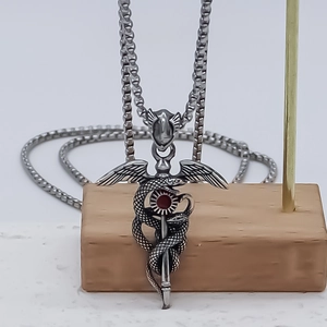Retro double snake caduceus pendant necklace with red gemstone and silver wing detail