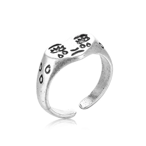 Retro punk crying face ring with teardrop pattern on a white studio background