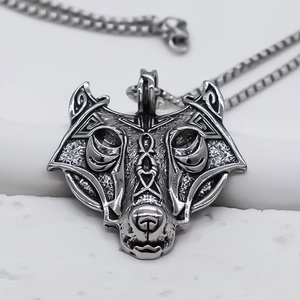 Detailed macro view of a Viking wolf head pendant with antique silver Celtic knot patterns