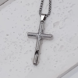 Detailed macro view of the silver cross whistle pendant with box chain on stone
