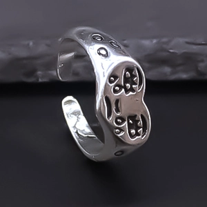 Macro shot of silver vintage punk style crying face engraved ring on stone base