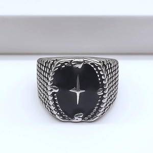 Detailed view of vintage silver ring with black oval enamel and star pattern