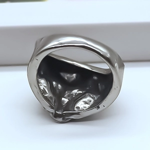 Vue macro d'une bague argentée avec texture de lave irrégulière et style avant-gardiste