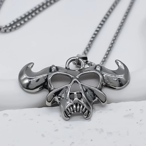 Vue macro d'un pendentif tête de mort taureau punk sur une chaîne box argent