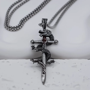 Vue macro du pendentif épée dragon rétro avec gemme rouge et collier chaîne maille