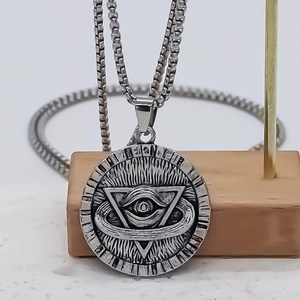 Vintage Eye of Horus round pendant necklace in silver stainless steel on wooden stand