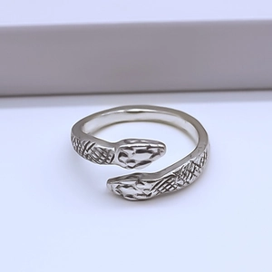 Detailed view of silver double snake head ring with intricate scale texture and open band