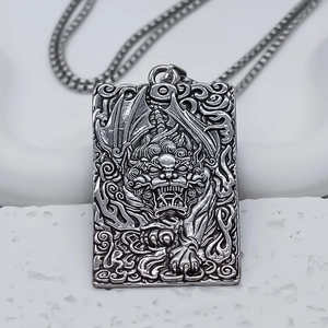 Detail of vintage silver rectangular pendant with relief of traditional mythical beast