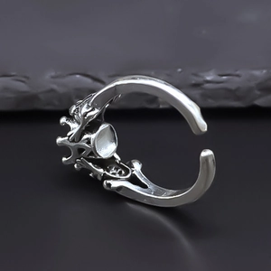 Macro shot of gothic skeleton hand ring with round claw setting on stone surface