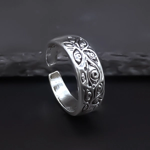 Detail of vintage silver eye relief patterns on an adjustable punk alloy ring band