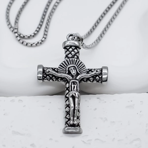 Gros plan détaillé d'un pendentif crucifix en acier inoxydable avec relief de Jésus et chaîne