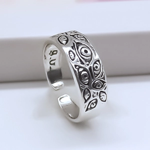 Detail of silver open ring featuring engraved evil eye patterns and antique finish
