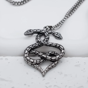 Macro shot of double snake heart pendant with vintage silver finish and scale texture