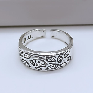 Macro view of silver adjustable open ring with embossed all-seeing eye gothic motifs