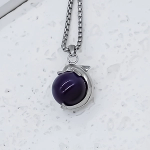 Silver dolphin pendant necklace with purple bead on white marble background