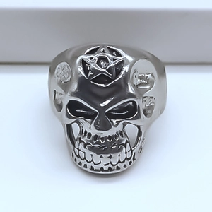 Dettaglio dell'anello punk a teschio argentato con un pentagramma inciso sulla fronte