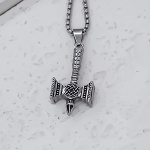 Macro view of stainless steel Viking double-headed axe pendant with Celtic knot details