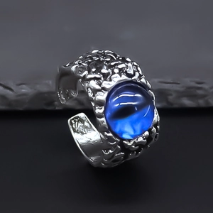 Macro detail of vintage punk evil eye ring with textured finish and blue oval stone