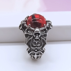 Detailaufnahme des gotischen Rings mit rotem Teufelsauge und silbernen Punk-Texturen