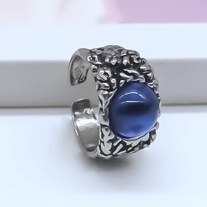 Detailed macro view of retro silver hammered texture ring with a blue oval gemstone