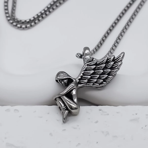 Gros plan du pendentif ailes d'ange en argent antique avec chaîne vénitienne