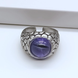 Macro detail of vintage punk dragon eye ring featuring silver texture and purple stone