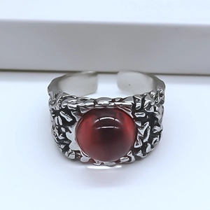 Macro shot of silver textured ring band featuring a vintage red evil eye cabochon stone