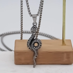 Punk style snake pendant necklace with detailed scales on a steel square link chain