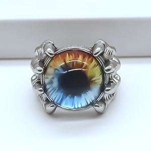 Detailed view of punk dragon claw ring holding a blue and orange evil eye sphere