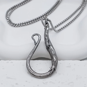 Détail macro du pendentif lézard argenté montrant les textures d'écailles en acier