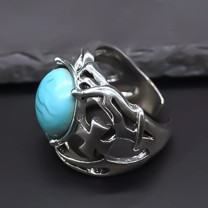 Detailed close-up of retro punk ring featuring oval turquoise and hollow cross patterns