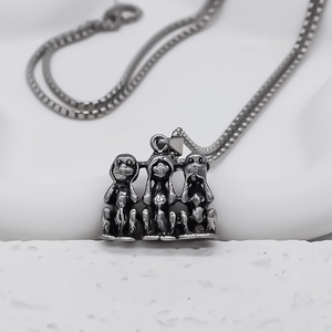 Dettaglio del ciondolo vintage tre scimmie sagge in argento su catena per collana da uomo