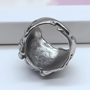 Vista macro di anello punk argento con trama a rilievo e design aperto regolabile