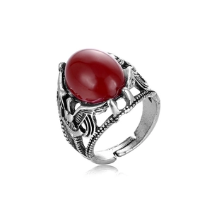 Vintage evil eye ring with red oval stone and carved silver wings on white background