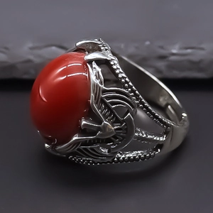 Macro shot of red evil eye ring with engraved silver metal detailing on grey stone
