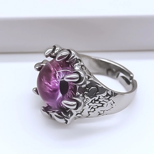 Gros plan d'une bague griffe de dragon punk avec une perle violette de mauvais œil