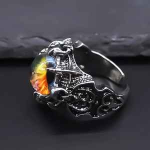 Macro shot of gothic dragon eye ring featuring a vibrant yellow pupil on a silver band