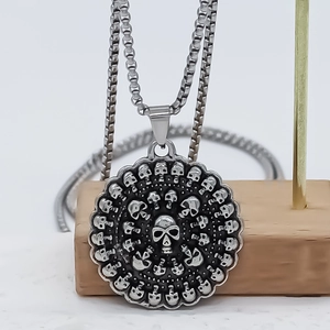 Collier punk avec pendentif rond à relief de crânes sur une chaîne à maillons carrés