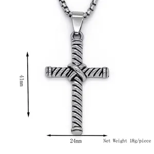 Collier pendentif croix argenté avec texture torsadée et chaîne box sur fond blanc