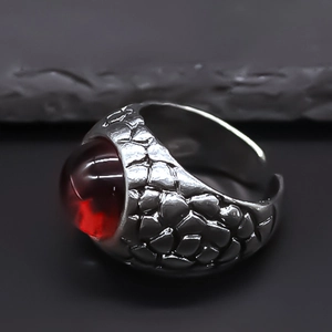 Detailed view of vintage silver ring with red gemstone and dragon scale texture