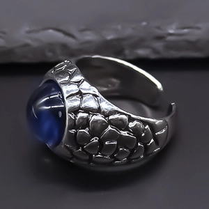 Detail of vintage eagle eye ring with blue stone and retro scale pattern alloy texture