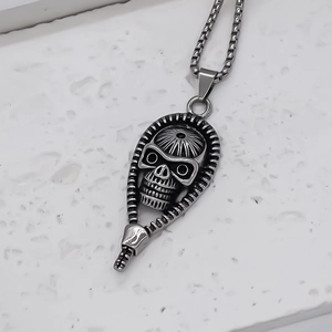 Punk pharaoh skull zipper pendant with square chain on white stone texture background