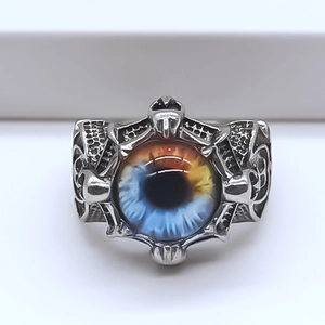 Macro view of gothic silver ring featuring a detailed blue and amber devil eye relief