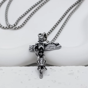 Detail of vintage gothic cross pendant with skull motif and silver square chain