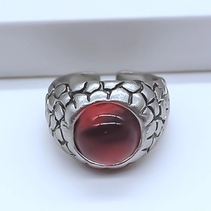Detailed close-up of a vintage eagle eye ring with red stone and dragon scale texture
