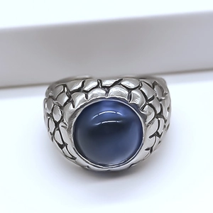 Macro shot of vintage silver eagle eye ring with blue stone and dragon scale texture