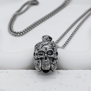 Détail d'un pendentif tête de mort punk en argent vintage avec chaîne à boîte