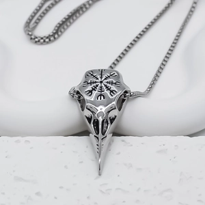 Détail d'un pendentif crâne d'oiseau argenté avec gravure de rune viking Aegishjalmur