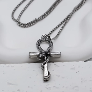 Close-up of vintage steel Ankh pendant with detailed snake texture on square bead chain